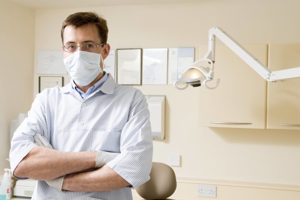 Dentist in exam room with mask on